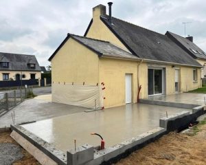 Dalle béton extérieure coulée le long d'une maison à Saint-Aubin-d'Aubigné, sur soubassement en parpaings, réalisée par BF Maçonnerie
