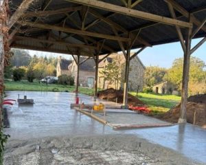 Coulage d'une dalle béton armé sous un hangar agricole à charpente bois à Saint-Aubin-d'Aubigné, réalisé par BF Maçonnerie
