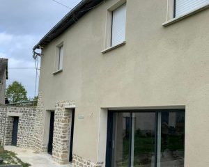 Façade enduite à la chaux sur une maison ancienne à Liffré, avec encadrements de portes en pierre apparente et grande baie vitrée, travaux BF Maçonnerie