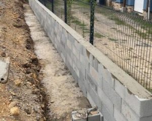 Mur en blocs à bancher surmonté d'une clôture grillagée à Saint-Aubin-d'Aubigné, réalisé par BF Maçonnerie